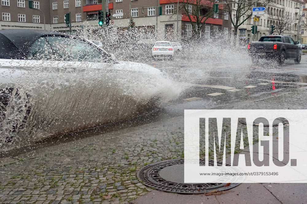 Berlin, GER car driving on a road through a big puddle everyday life, cropping, aquaplaning, exterior, exterior shot, auto