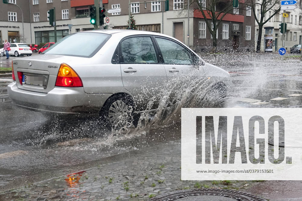 Berlin, GER car driving on a road through a big puddle everyday life, aquaplaning, exterior, exterior shot, automobiles, cars, car tr