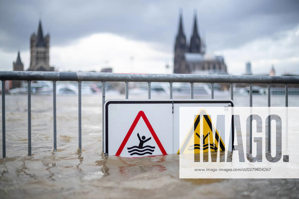 Flood in Cologne the barrier, on which hangs a sign that says Flood danger of life, Danger, keep out when flooded, on the background we see Cologne Cathedral Flood in Cologne, symbolic image, 26 12 2023 Cologne NRW Germany