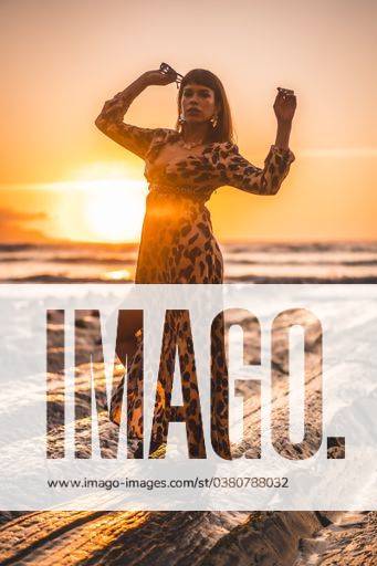 A vertical shot of a young female in leopard dress on a beautiful sunset on the beach 642237 ,model released, Symbolfoto RECORD DATE NOT STATED