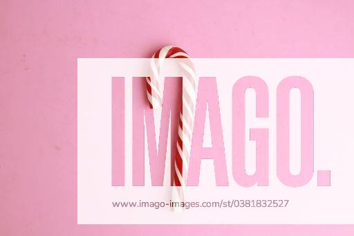 A top view of a candy cane under the lights against a pink background 723786 RECORD DATE NOT STATED