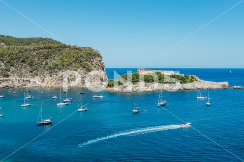 Picturesque scenery of turquoise sea with boats sailing and green mountains in Balearic Islands (Ibiza) Spain in sunny day sea cliff picturesque coast spain summer scenery mountain water island landscape seascape tourism freedom turquoise vacation travel seaside idyllic trip scenic coastline seashore breathtaking seacoast harmony journey majestic tranquil paradise amazing summertime formation nature rocky sky boat ship sailing ibiza sant miquel sunny cloudless blue sky green tree environment