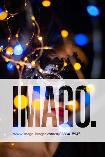 IMAGO Creative, Gesellschaft, Fasching A vertical shot of a Hispanic young woman with a carnival mask and bokeh lights 1417722 ,model released, Symbolfoto RECORD DATE NOT STATED