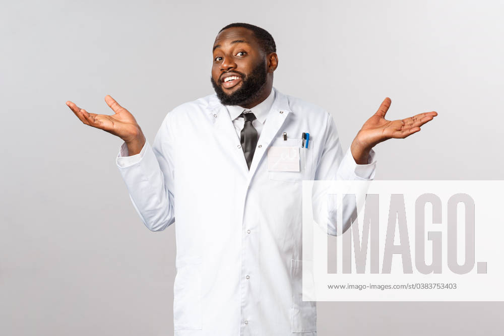 Coronavirus, covid19 and healthcare concept. Dont know cant help sorry. Portrait of reluctant, unbothered handsome african-american doctor shrugging clueless, puzzled and have no idea Coronavirus, covid19 and healthcare concept. Dont know cant help sorry. Portrait of reluctant, unbothered handsome african-american doctor shrugging clueless, puzzled and have no idea. ,model released, Symbolfoto