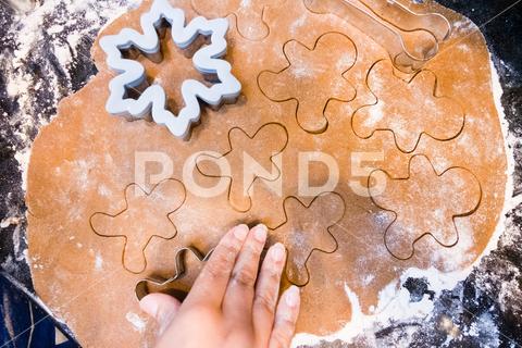 Overhead view of small hand cutting out Christmas cookies. bake baking boys brothers celebration child christmas cookie cookies december decorate decorating decoration dessert dough festive flour gingerbread gingerbread man hands happy holiday homemade snowflake sugar sweet traditional winter xmas washington district of columbia united states gradeschooler 5-7 years old one person male hispanic latino
