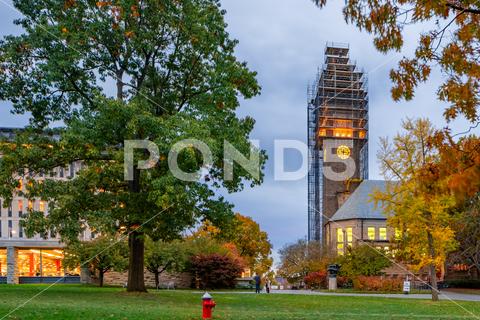Night photo of McGraw clock tower with construction scaffolding, landmark at Cornell University, and iconic presence on campus. University found in 1865 mcgraw tower cornell university college architecture scaffolding campus clock ivy league student clock-tower construction landmark 1865 ithaca ny new york finger lakes upstate study teaching education higher stone iconic design engineering learning structure institution lecture special evening dark school american building fall trees