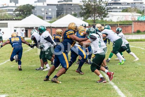 American football players vie for the ball at the Armando Oliveira stadium in the city of Camacari, Bahia. sport stadium success field football challenge men team player helmet uniform ball effort athlete professional competitive american football player match american football attack aggression lifestyle outdoor score championship catch jump goal pass players rugby league defender tackle champion game sportsman defense cavalry 2 de Julho Camacari Bahia Brazil