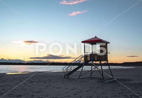 View of a lifeguard deck on the shore of the sea at sunset time beach beautiful blue clouds coast coastline dusk evening horizon landscape lifeguard light nature ocean orange outdoor red sand scenic sea sky summer sun sunrise sunset tourism tower travel vacation water finland yyterri pori satakunta no people