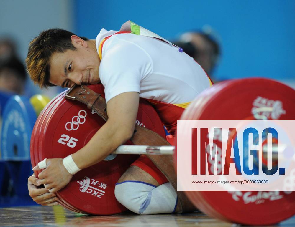Zhang Xiangxiang (China) hat nach seinem Olympiasieg die Gewichte ganz lieb - Gewichtheben OS Sommer Herren Olympische Spiele Peking 2008, Sommerspiele, Klasse bis 62kg Einzelbild Peking Romantik, Freude,