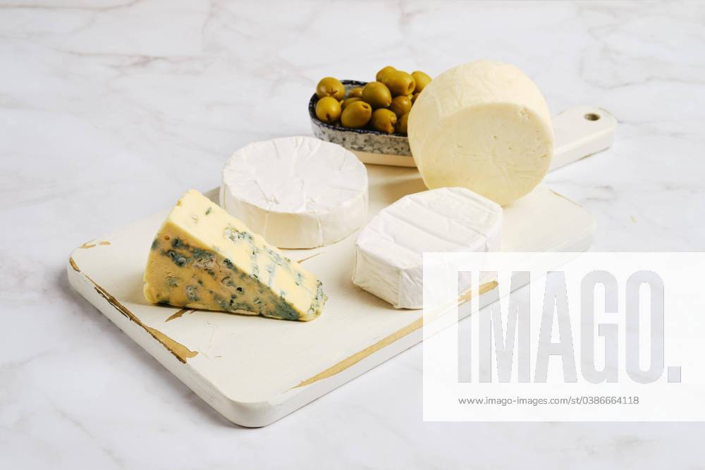 Pieces from Brie, Camembert, Goat cheese and Cheese with Blue mold at Wooden board