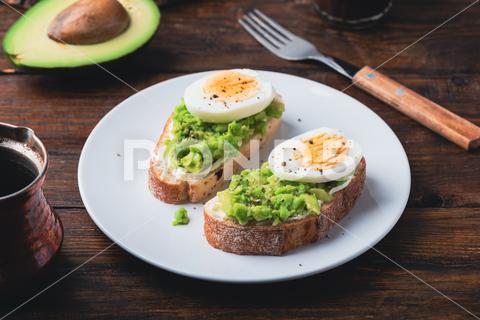 IMAGO Creative, Food, High Protein Frühstück Toasts with mashed avocado, cream cheese and slices of boiled egg on plate and turkish coffee avocado toast egg snack coffee breakfast vegetable healthy eating sandwich guacamole boiled egg bread bruschetta food green meal cream cheese dish diet cooking cuisine fruit brunch eat ciabatta mashed ready-to-eat slice drink turkish coffee cezve plate morning homemade wooden