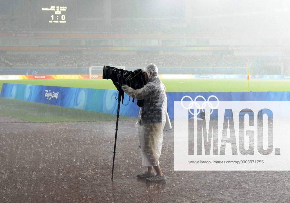 Sportfotograf trotzt dem Regen - extreme Witterungsbedingungen führen zum zeitweiligen Spielabbruch beim in Shanghai ausgetragenen Viertelfinale der Olympischen Spiele - Fußball OS Sommer Damen Olympische Spiele Beijing 2008, Sommerspiele, Länderspiel, Nationalteam Viertelfinale Einzelbild Frauen, Frauenfußball Shanghai