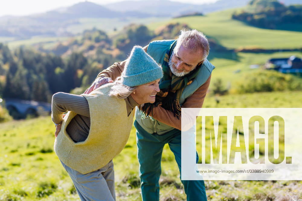 Senior woman with having pain in back during autumn walk, her husband taking care of her. Senior woman with having pain in the back during autumn walk, her husband taking care of her. model released