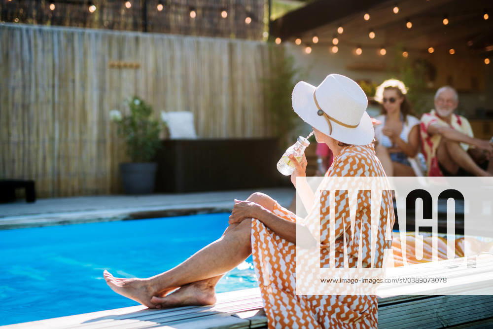 Senior woman enjoying time at swimmingpool with her family. Senior woman enjoying summer time at swimmingpool with her family. model released