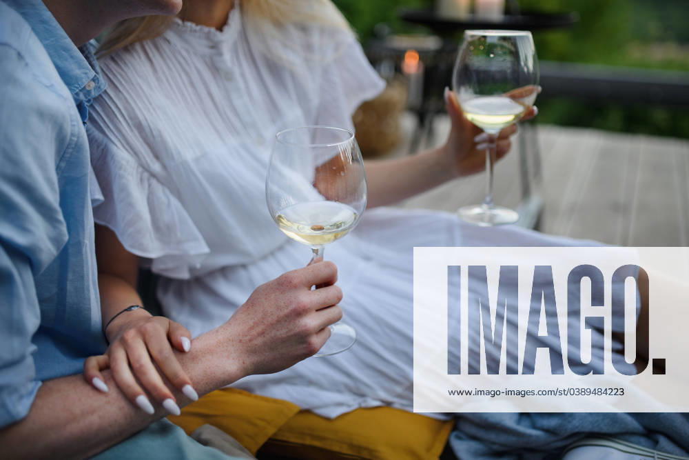 Young couple clinking with wine outdoors, weekend away in tiny house in countryside, sustainable living. Close-up. A young couple clinking with wine outdoors, weekend away in tiny house in countryside, sustainable living. Close-up. model released
