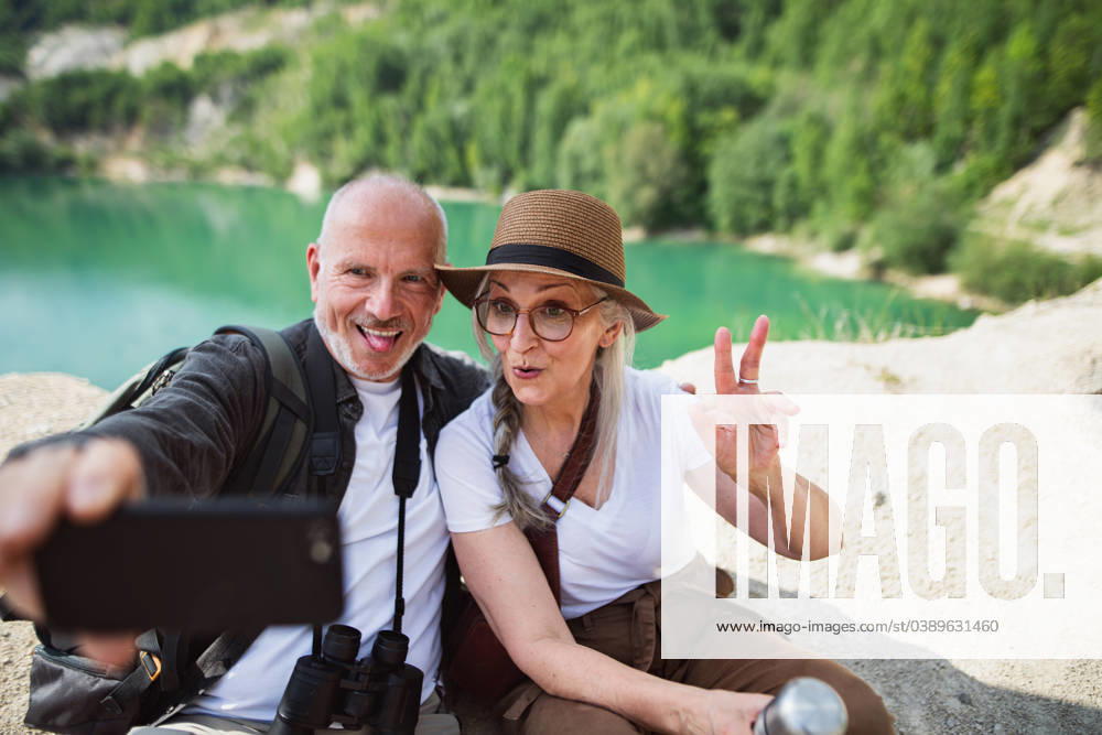 Happy senior couple on hiking trip on summer holiday, making faces when taking selfie. A happy senior couple on hiking trip on summer holiday, making faces when taking selfie. model released