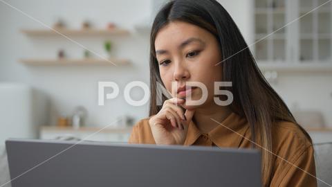 Smart pensive Asian chinese woman 30s businesswoman work from home kitchen thoughtful writer think business plan contemplate search media online on laptop doubtful korean girl thinking idea decision. High quality 4k footage think pensive asian woman dreaming chinese smart 30s businesswoman sit kitchen creative designer writer business plan contemplate search media online laptop doubtful korean girl thinking idea decide decision thoughtful create solution pondering puzzled searching ponder analyze thoughts confused problem contemplating concentrating doubt thought job planning solving startup computer internet