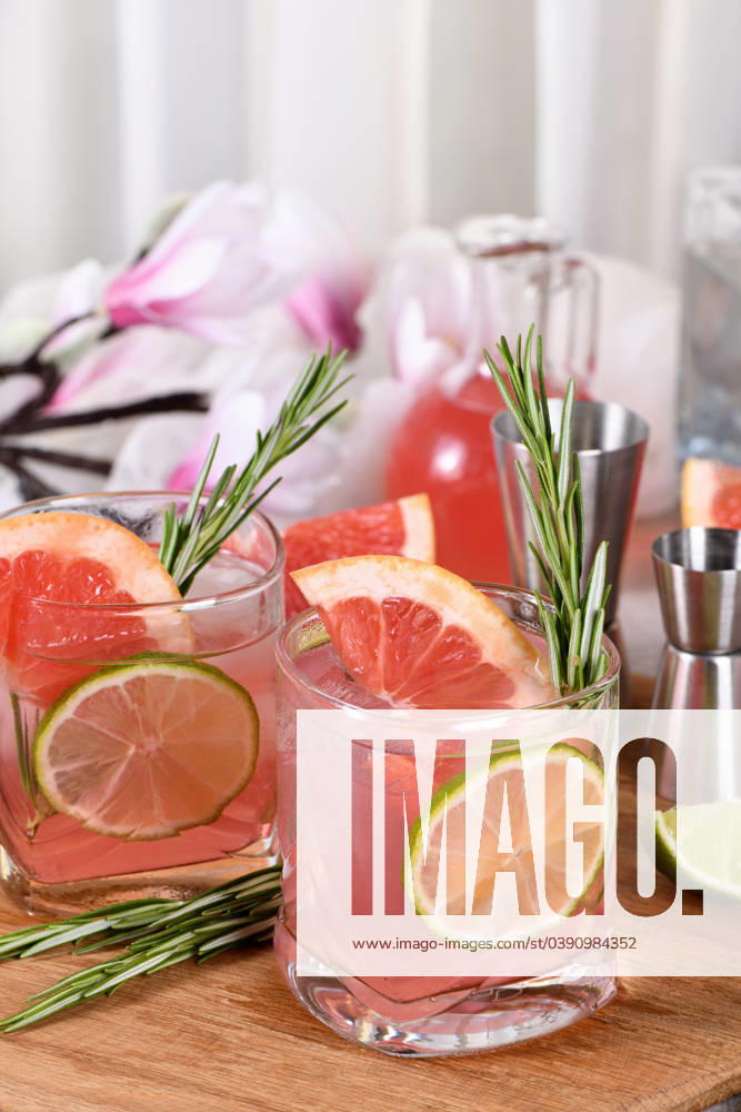 Pink Paloma cocktail red grapefruit with tonic Refreshing organic cocktail with grapefruit slice, lime and rosemary sprig in a glass