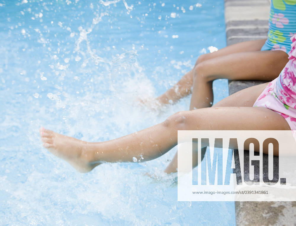 Hispanic girls splashing water in swimming pool Huntington Station, NY, 21.12.2023, model released, TTBB_BLD066963.jpg, 4-5 years, 6-7 years, active, barefoot, bathing suit, blurred motion, carefree, childhood, close up, color image, copy space, day, elementary age, energy, exhilaration, foot, friend, friendship, fun, girl, high angle view, horizontal, kicking, latin american and hispanic ethnicity, latina, leisure activity, low section, motion, only girls, outdoors, people, photography, playing, poolside, recreation, refreshing, side view, sister, sitting, splashing, summer, sunny, swimmer, swimming, swimming pool, together, two people, vacation, weekend activities, wetting, minority, minorities2, action, amusement, apparel, bathing costu