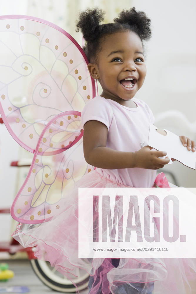 African American girl in fairy costume Jersey City, NJ, 21.12.2023, model released, TTBB_BLD072830.jpg, 12-17 months, african ethnicity, baby, baby girl, childhood, color image, costume, cute, domestic life, dress, fairy, happy, holding, imagination, indoors, innocence, leisure activity, lifestyle, looking up, mouth open, one baby girl only, one person, people, photography, pigtail, playing, smiling, standing, three quarter length, vertical, wing, minority, minoritiesafrican, african american, african-american, afro american, afro-american, apparel, black, bliss, cheerful, child, children, clothes, clothing, color, colour, delight, delighted, dress up, dress-up, dressing up, enjoyment, frock, fun, gaiety, garment, girl, glad, gleeful, gown