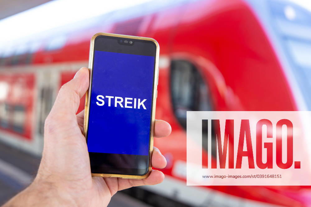 Symbolic image GDL strike Gewerkschaft deutscher Lokomotivführer Close-up of a smartphone in front of a regional train