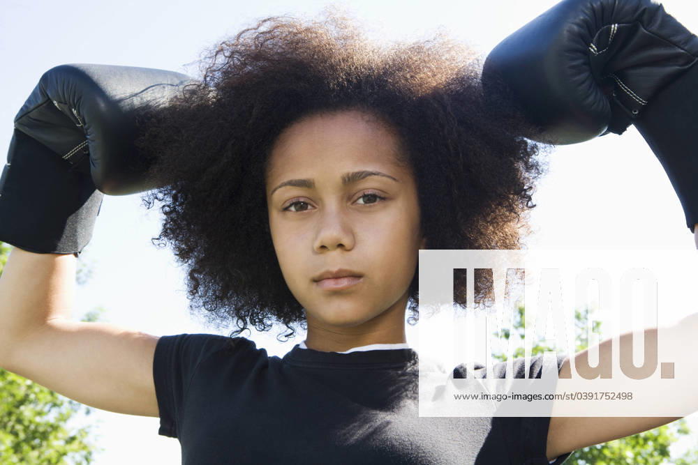 Serious teenage girl wearing boxing gloves Elk Grove, CA, USA, 21.12.2023, model released, TTBB_BLD099029.jpg, active, african-american ethnicity, aggression, arms raised, athletic, attitude, biceps, boxer, boxing gloves, brunette, childhood, close up, color image, competition, confidence, day, flexing, front view, head and shoulders, horizontal, looking at camera, low angle view, one person, outdoors, people, photography, portrait, posing, practicing, pride, rebellion, recreation, serious, sports, standing, strength, teenage girl, teenage girls, training, youth culture,, minority, minorities, gritaction, african, african american, african ethnicity, african-american, afro american, afro-american, aggressive, amusement, arm, bicep, black,
