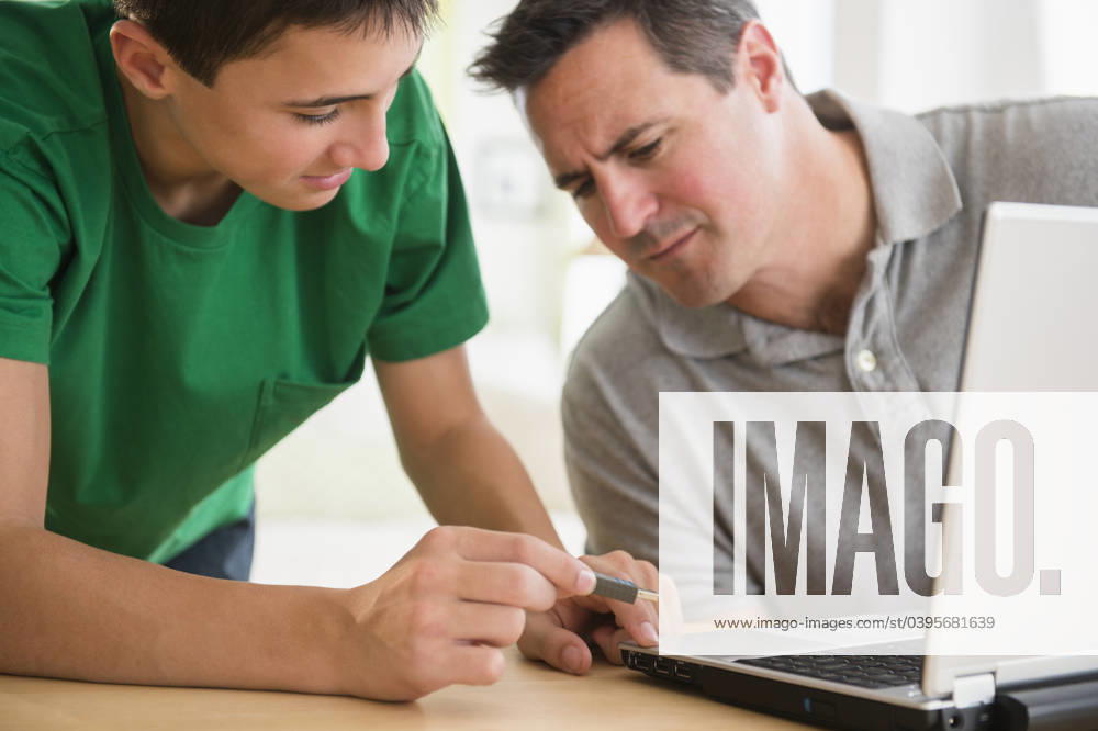 Caucasian son showing father how to use USB stick in laptop Jersey City, New Jersey, USA, 06.11.2013, model released, TTBB_BLD126483.jpg, 12-13 years, 40-44 years, access, accessibility, adolescence, assistance, bonding, boy, boys, brunette, caucasian, childhood, close up, color image, communication, concentration, confusion, connection, convenience, day, domestic life, e-mail, emailing, external hard drive, family with one child, father, generation gap, generational gap, guidance, guiding, head and shoulders, helping, holding, horizontal, indoors, information, information management, inserting, internet, laptop, learning, lifestyle, looking down, man, mature adult, mature men, mobility, modern, one parent, online, people, photography, por