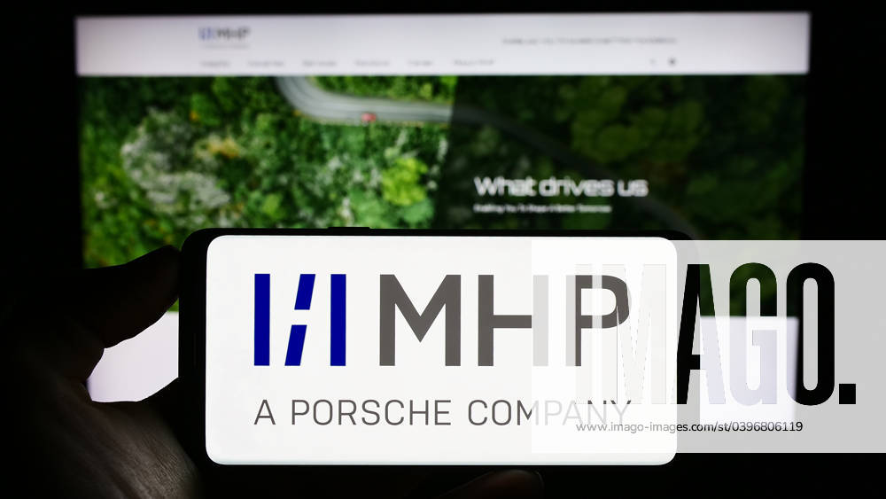 Person holding mobile phone with logo of company MHP Management- und IT-Beratung GmbH on screen. Stuttgart, Germany - 08-20-2023: Person holding mobile phone with logo of company MHP Management- und IT-Beratung GmbH on screen in front of web page. Focus on phone display.