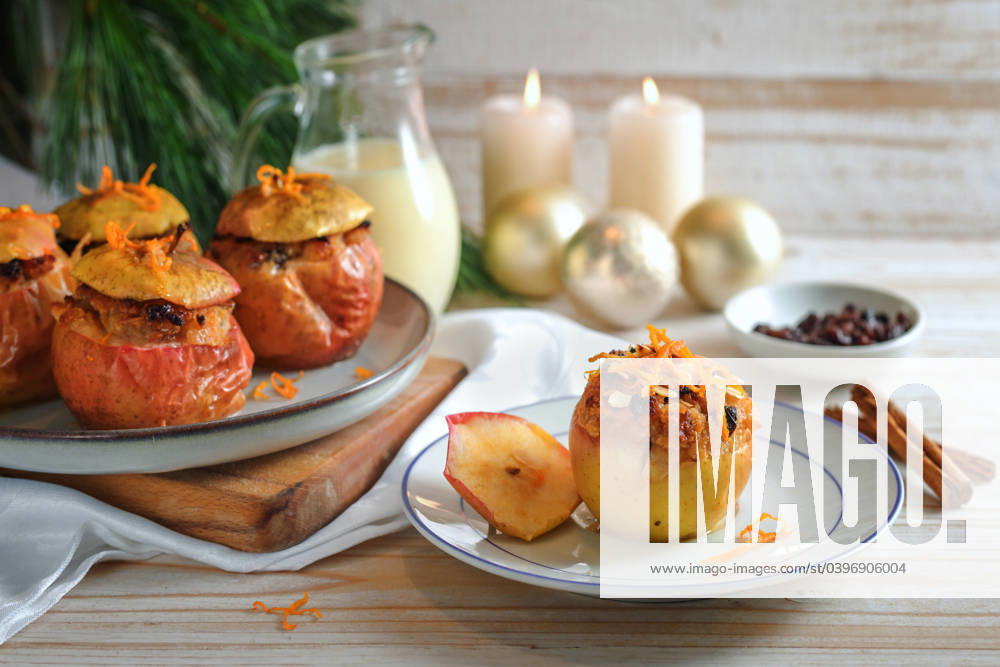 Baked apples fresh from the oven with filling of almond, honey, and raisin, garnished with orange zest on a wooden table with Christmas decoration, festive holiday dessert, copy space Baked apples fresh from the oven with filling of almond, honey, and raisin, garnished with orange zest on a wooden table with Christmas decoration, festive holiday dessert, copy space, selected focus