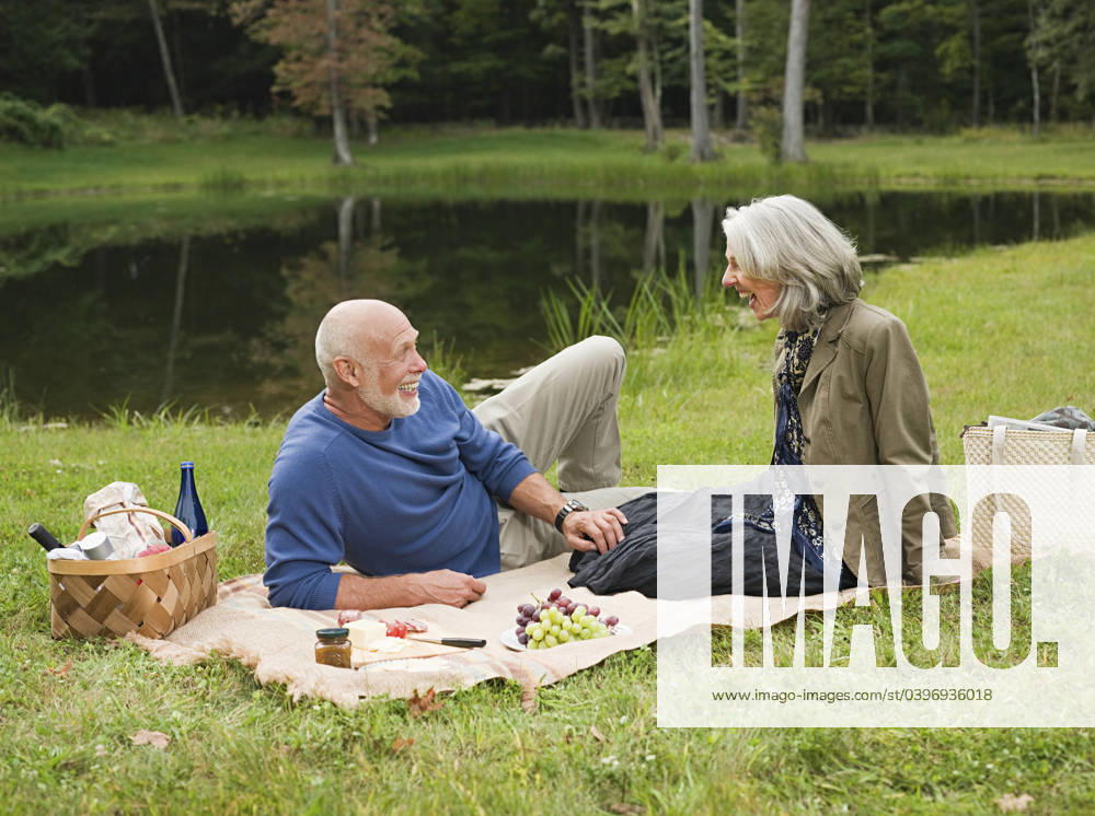 Older couple relaxing at picnic in park Accord, New York, USA, 21.12.2023, model released, TTBB_BLD170626.jpg, 55-59 years, 65-69 years, accord, aging, authentic, authenticity, beauty in nature, bonding, boyfriend, calm, caucasian, color image, conversation, copy space, countryside, day, enjoying, enthusiasm, environment, foliage, food and drink, forest, fun, getting away from it all, girlfriend, grass, happy, heterosexual couple, horizontal, husband, lake, laughing, lawn, leisure activity, lifestyle, looking, love, man, mature adult, mature women, nature, new york, older, outdoors, park, peace, people, photography, picnic, picnic basket, picnic blanket, pond, quality time, real people, recreation, relaxation, retirement, romance, rural sc