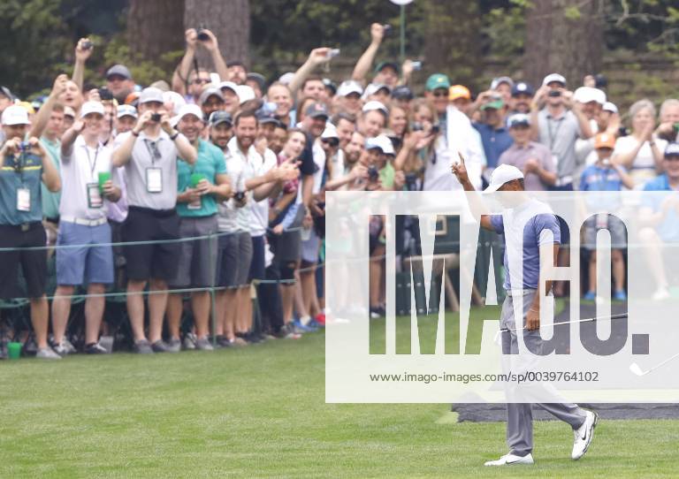 Fans react after Tiger Woods, Justin Thomas and Fred Couples skip balls across the water on the 16th green when they practice on the Monday before the 2019 Masters Tournament at Augusta National Golf Club in Augusta, Georgia, on April 8, 2019. AUG20190408110 JOHNxANGELILLO