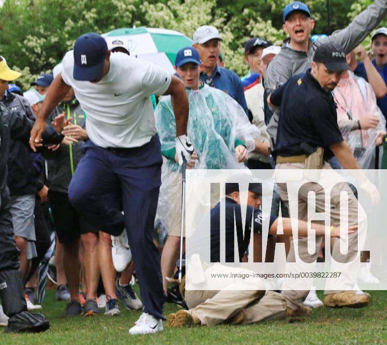 Golf: Masters Tournament Tiger Woods is almost felled by a sliding security guard after hitting his second shot on the 14th hole during the second round of the Masters Tournament at Augusta National Golf Club in Augusta, Georgia, on April 12, 2019.