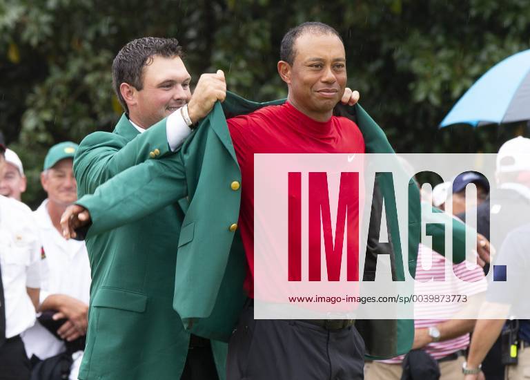2018 champion Patrick Reed places the Green Jacket on Tiger Woods after the final round at the 2019 Masters Tournament at Augusta National Golf Club in Augusta, Georgia, on April 14, 2019. Tiger Woods wins the Masters with a score of 13 under par for his 5th Green Jacket. AUG20190414921 JOHNxANGELILLO