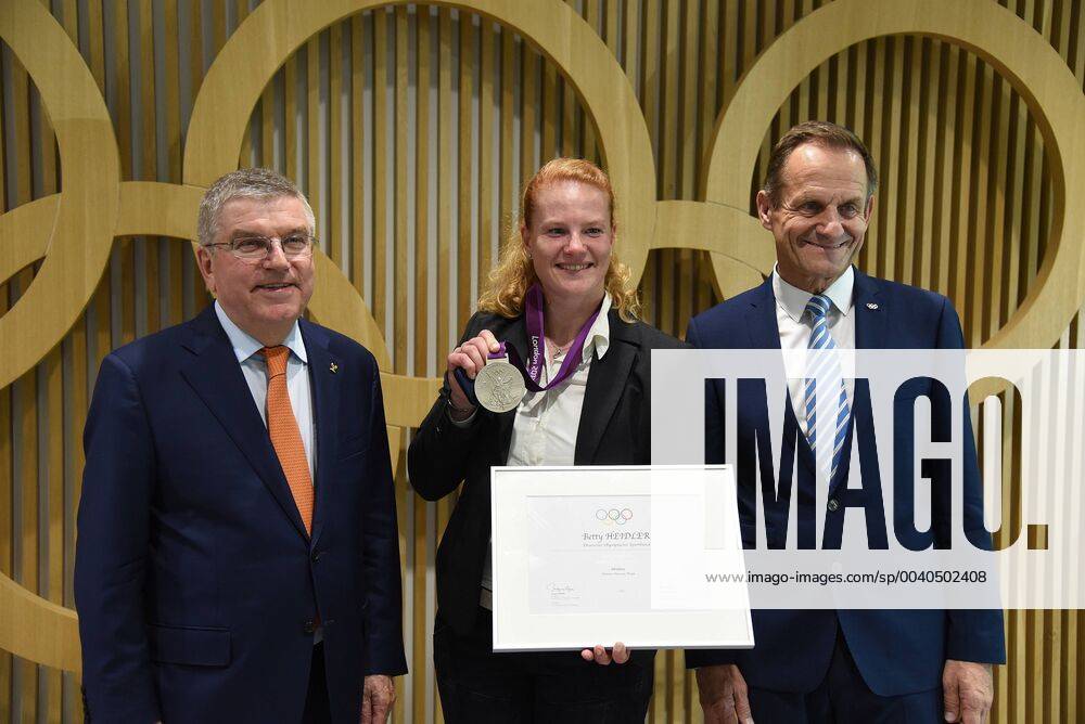Frankfurt am Main Celebration at the Haus des Sports at the DOSB in Frankfurt Betty Heidler receives silver medal from London 2012 Picture shows Thomas Bach, President of the International Olympic Committee IOC Ex hammer thrower Betty Heidler DOSB President Alfons Hörmann