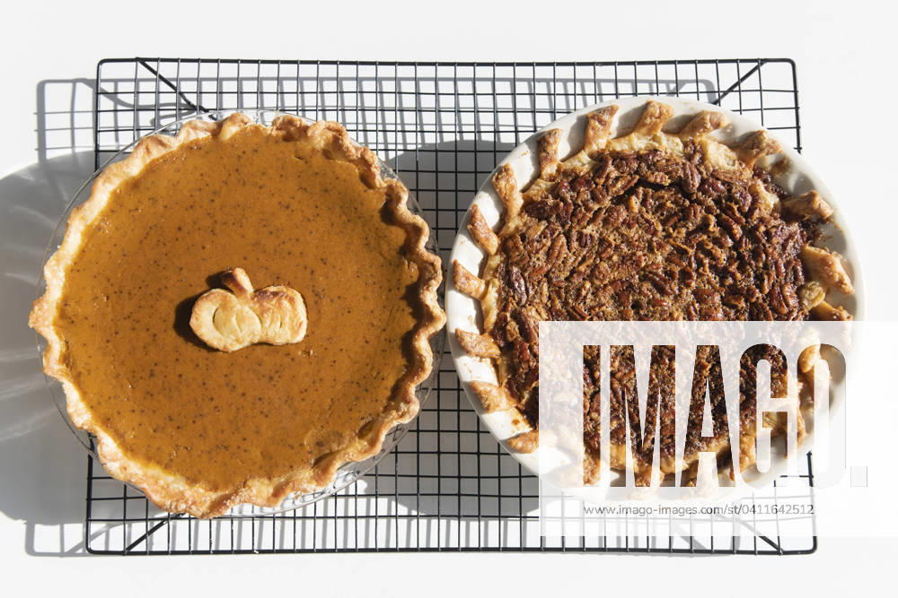 IMAGO Creative, Herbst, Food, Pumpkin Pie Pumpkin and pecan pies on a cooling rack , 20.12.2023, TTBB_ti0002_03737.jpg, Pecan,Thanksgiving,American Culture,Food And Drink,Traditional Culture,Celebration,Studio Shot,Color Image,Horizontal,Directly Above,No People,Still Life,Three Objects,White Background,Pie,Shadow,Cooling,Rack,Nut,Baked,Ready To Eat,Dessert,Sweet Food,Indulgence,Pumpkin