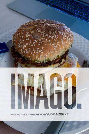 A vertical shot of vegetarian halloumi egg burger with a fork on a plate 2921141