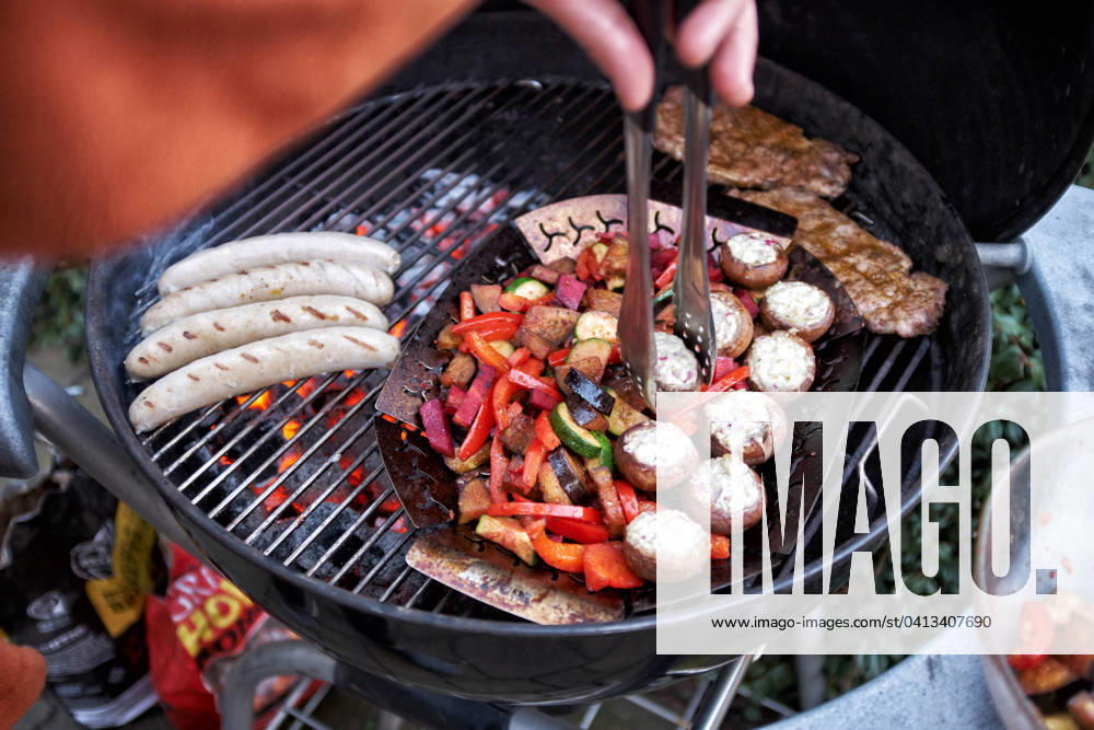 Barbecue at a Round grill become simultaneously Sausages, Steaks and Vegetables grilled Food NRW