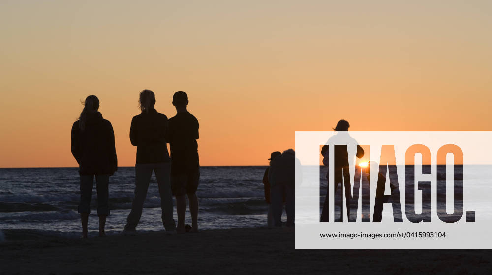 Canada, Ontario, A family watches the sunset over Lake Huron at Sauble Beach.