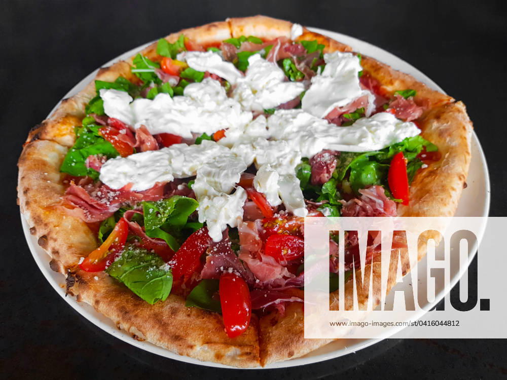 Wood-fired oven pizza with parma ham and burrata cheese Wood-fired oven pizza ready to eat horizontal close-up shot ,model released, Symbolfoto