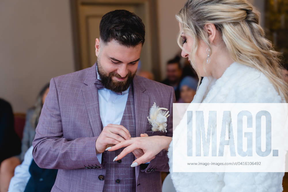 Man puts wedding ring on woman s finger at civil wedding
