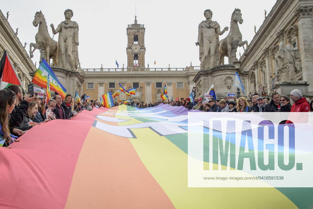 People hold a large banner with the colors of peace and the words peace during the flashmob in support of Peace and for the ceasefire on the occasion of the National Day of Mobilization for the Ceasefire in Palestine and UkraineÃ‚ promoted by the Europe coalition for Peace and AssisiPaceGiusta in Rome. Rome Italy - ZUMAv147 20240224_zip_v147_005