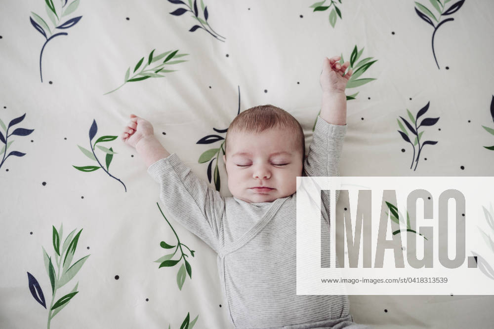 Cute baby girl stretching arms lying in bed at home model released, Symbolfoto property released, EBBF08434