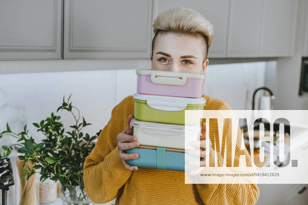 IMAGO Creative, Food, Trend, Meal Prep Young woman holding lunch boxes in kitchen at home model released, Symbolfoto property released, YTF01691