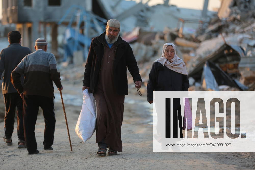 (240305) -- GAZA, March 5, 2024 -- People walk past destroyed buildings at Al-Maghazi refugee camp in central Gaza Strip, on March 5, 2024. The Palestinian death toll in the Gaza Strip from ongoing Israeli attacks has risen to 30,631, the Hamas-run Health Ministry said on Tuesday. MIDEAST-GAZA-AL-MAGHAZI REFUGEE CAMP Dawood