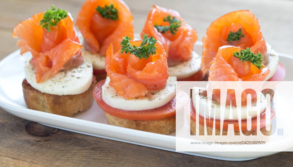 Canapes with red fish canapes with salmon and cheese on wooden table