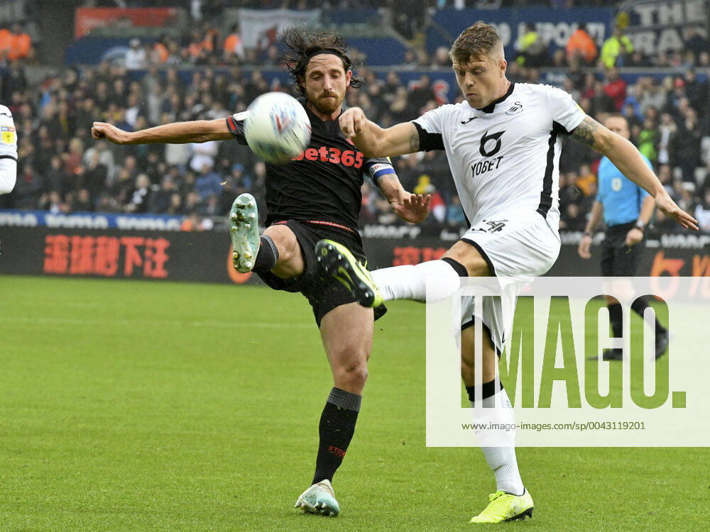 Football - 2019 2020 Sky Bet (EFL) Championship - Swansea City vs. Stoke City Joe Allen of Stoke City & Jake Bidwell of Swansea City of Swansea City, at the Liberty Stadium. COLORSPORT WINSTON BYNORTH