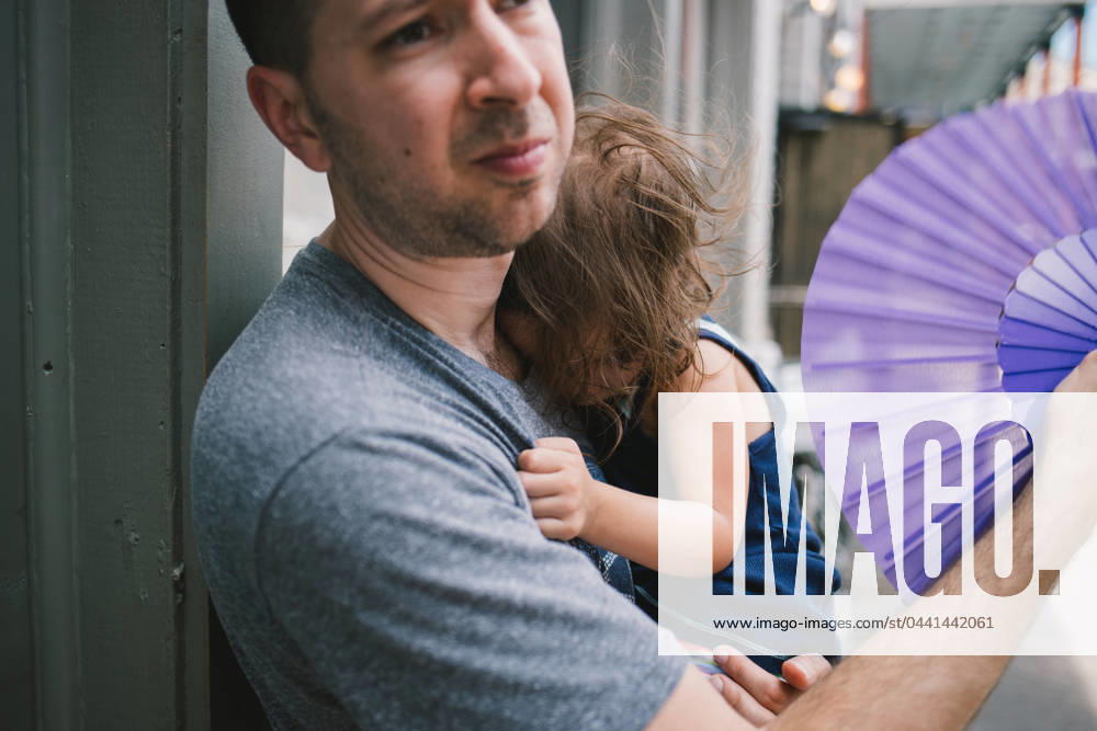 IMAGO Creative, Jahreszeit Sommer, Hitze Man holds sleeping daughter while fanning her on hot summer day New Orleans, Louisiana, United States R_SXFI24031956-1359348-01 ,model released, Symbolfoto