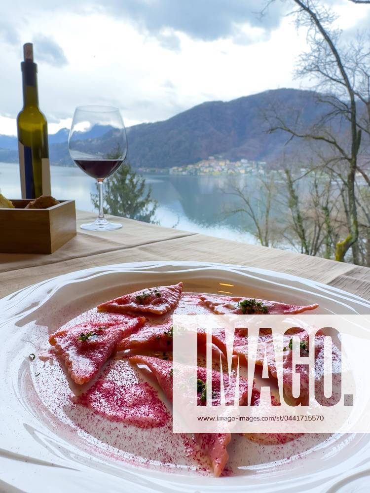 Restaurant table with red Pray Ravioli at a white Plate with Mountain view in the Switzerland