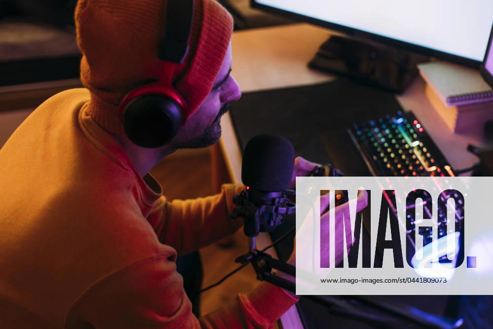 IMAGO Creative, Lifestyle, Gaming Gaming influencer wearing wireless headphones and playing video games at home model released, Symbolfoto property released, EGHF00836