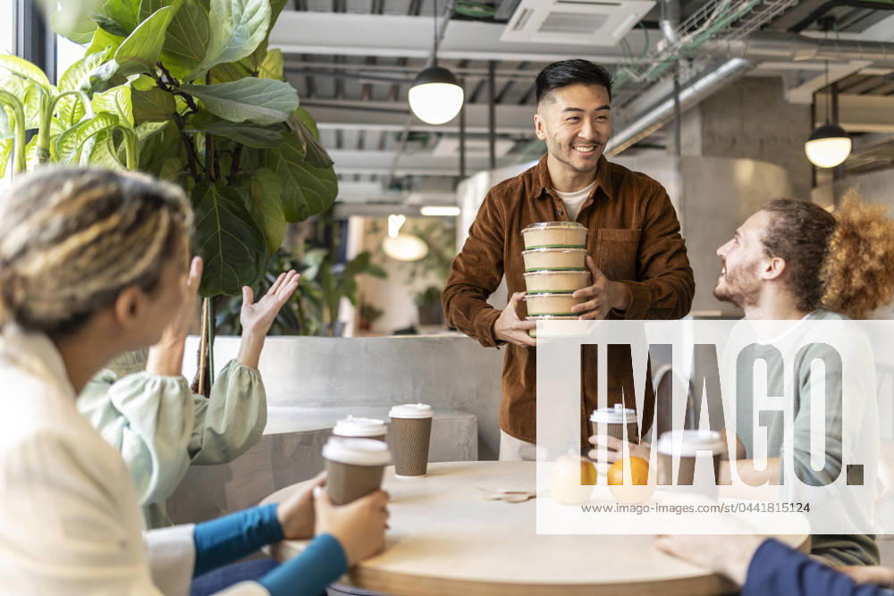 Smiling businessman holding stack of containers at lunch break in office model released, Symbolfoto property released, JCCMF11304